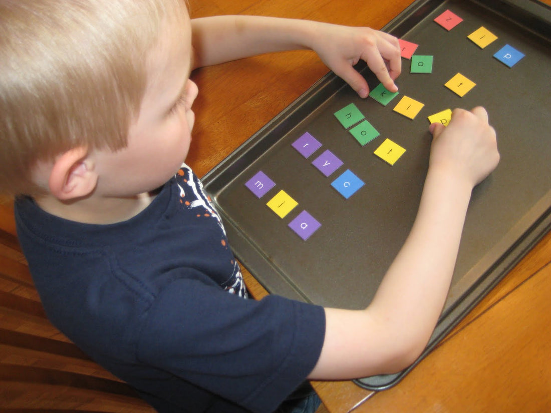 The image shows a boy playing unscrambled words in a table with alphabet word puzzles