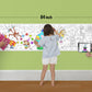 The image depicts a father and his two daughters enjoying a bonding moment while colouring circus sheet attached to the wall.