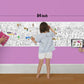 The image depicts a father and his two daughters enjoying a bonding moment while colouring find the hidden objects sheet attached to the wall.