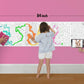 The image depicts a father and his two daughters enjoying a bonding moment while colouring find the path sheet attached to the wall.