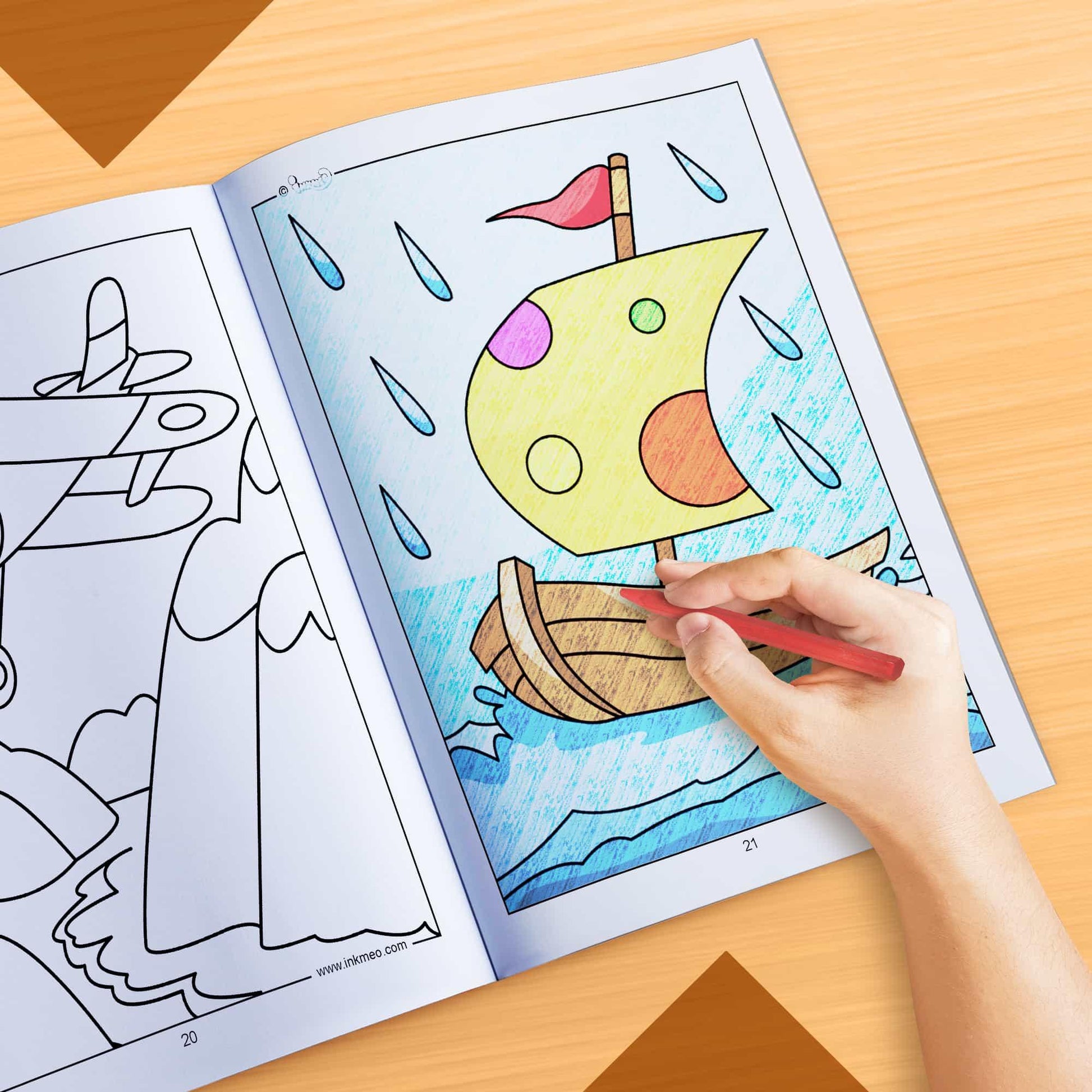 The image depicts a hand coloring a book with crayons.