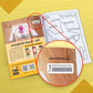 The image depicts a yellow background with an open book placed on it, with an activation code zoomed in from the book.