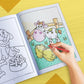 The image depicts a hand coloring a book with crayons.