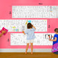The image depicts a father and his two daughters enjoying a bonding moment while coloring tamil karpom combo pack sheet attached to the wall.