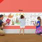 The image depicts a father and his two daughters enjoying a bonding moment while colouring christmas carols roll attached to the wall.
